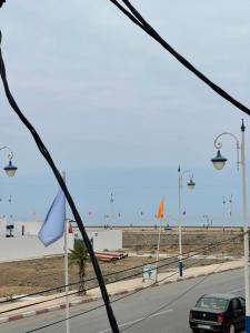 a car driving down a road next to a beach at شقة للكراء بشاطئ زمانة بالجبهة in El Jebha