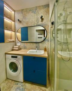 a bathroom with a sink and a washing machine at Apartament Gruszowe Sady Nowaka 6 in Olsztyn