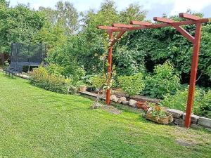a garden with a wooden pergola in the grass at Liepājas brīvdienu māja ar dārzu in Liepāja