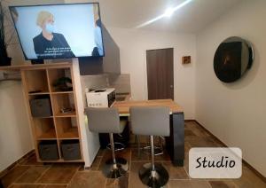 a room with a table and a tv on a wall at Studio moulin la paille in Veyre-Monton