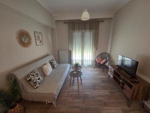 a living room with a couch and a flat screen tv at La mer in Moúdhros