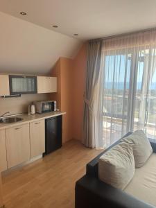 a living room with a kitchen and a large window at Red Iguana Hotel in Sveti Vlas