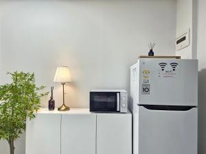 a microwave sitting on a counter next to a refrigerator at Shinhwahouse 5 mins from Seoul Station in Seoul +24 photos