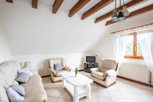 un salon avec un canapé, des chaises et une télévision dans l'établissement Route des vins d'Alsace, domaine viticole 'Pinot Gris', à Pfaffenheim