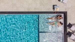 una vista panoramica di 2 persone che nuotano in una piscina di Hotel Rombino a Fonteblanda