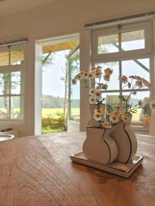 two vases with flowers in them sitting on a table at BnB Nest & Weide in Nijeberkoop