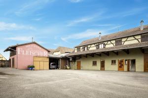 un bâtiment avec une enseigne sur le côté dans l'établissement Route des vins d'Alsace, domaine viticole 'Pinot Gris', à Pfaffenheim