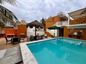 a swimming pool in front of a building with a restaurant at Departamentos a 200 mts de la playa in Chuburná