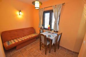 a dining room with a bench and a table at Falcone Apartments in Đenovići