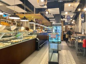 eine Bäckerei-Abteilung mit einer Theke und Menschen, die an Tischen sitzen in der Unterkunft Luz Madrid Rooms in Madrid