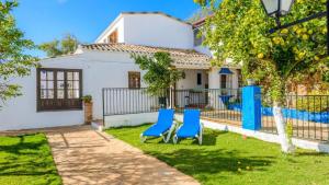 two blue chairs in the yard of a house at Casa Carmela in Priego de Córdoba