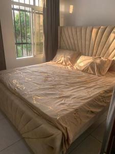 a large bed in a room with a window at Mtwapa behind mzuri sweet company in Mtwapa