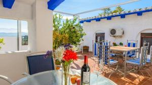a table with a bottle of wine and a vase with flowers at Casa Carmela in Priego de Córdoba