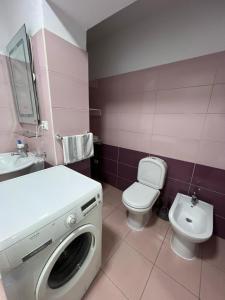 a bathroom with a washing machine and a toilet at City Center Bazaar Apartment in Tirana