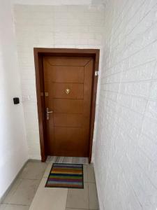 a hallway with a wooden door with a rug in front at City Center Bazaar Apartment in Tirana +4 photos