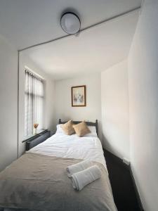 a bedroom with a large white bed with a mirror at 2 Bed Apartment off London Road in Sheffield