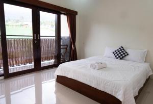 Ένα ή περισσότερα κρεβάτια σε δωμάτιο στο Medjora Homestay Kemuning
