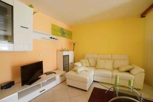 ein Wohnzimmer mit einem weißen Sofa und einem Fernseher in der Unterkunft Apartment Pula 15 in Pula