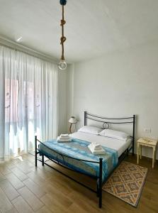 a bedroom with a bed and a large window at Austinu e Bingedda's Home in Ardara