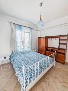 a bedroom with a bed and a desk and a window at Althea Apartment in Skopelos Town