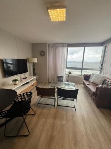 a living room with a couch and a table and chairs at Infinity Beach view in Cape Town