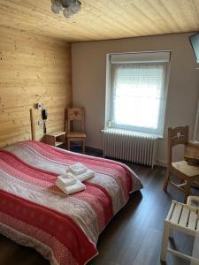 ラ・ブレスにあるAuberge des Skieursのベッドルーム1室(ベッド1台、窓、椅子付)