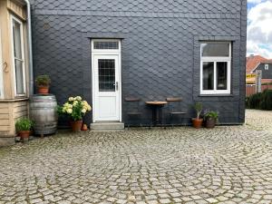a black house with a white door and a table and chairs at Wandergesellenzimmer mit Bad und Küche in Ilmenau