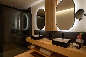 ein Badezimmer mit zwei Waschbecken und zwei Spiegeln in der Unterkunft Hotel do Alboi in Aveiro + 87 Fotos