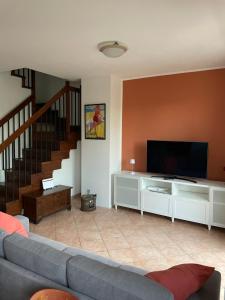 a living room with a couch and a flat screen tv at Verdemare Apartments in Fano