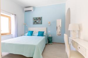 ein blaues Schlafzimmer mit einem Bett und blauen Kissen in der Unterkunft B&B Elysia in Lipari