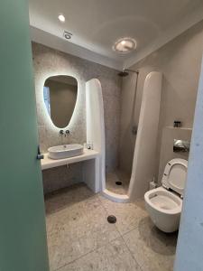 une salle de bain avec toilettes, lavabo et miroir dans l'établissement Abadéli, à Naxos Chora 28 autres photos