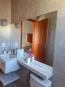 a bathroom with two sinks and a large mirror at Casa aconchegante in São Thomé das Letras +24 photos
