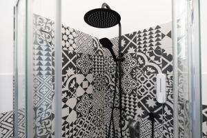 a shower with a black and white patterned wall at B&B Elysia in Lipari +62 photos