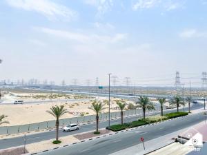 a highway with palm trees on the side of a road at Bright 2Bed Family Home l Pool , Gym access in Dubai