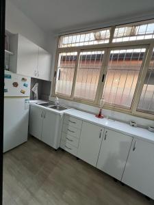 a kitchen with white appliances and a large window at City Center Bazaar Apartment in Tirana
