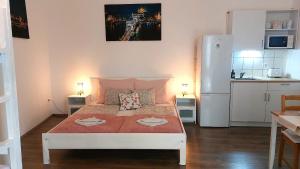 a small room with a bed and a refrigerator at GoodMo Budapest Smart Rooms in Budapest