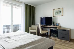 a bedroom with a bed and a desk with a television at Litzlberger Keller am Attersee in Seewalchen