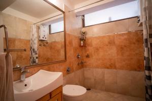 a bathroom with a sink and a toilet and a mirror at Lake View 2BHK close to Mall Road l Bay Breeze in Nainital +13 photos