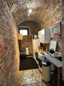 a room with a brick wall and a kitchen at Rodar in Boguszów-Gorce