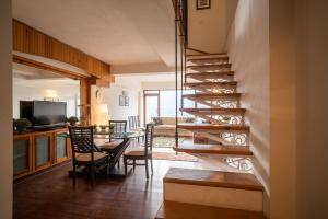 a staircase in a living room with a table and chairs at Lake View 2BHK close to Mall Road l Bay Breeze in Nainital