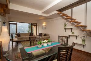 a dining room and living room with a table and chairs at Lake View 2BHK close to Mall Road l Bay Breeze in Nainital