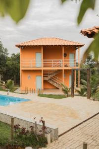 una casa con piscina delante de ella en Sítio Jaboticatubas, en Jaboticatubas