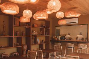 a restaurant with tables and chairs and lights at Pousada Casa Mandacaru Noronha in Fernando de Noronha