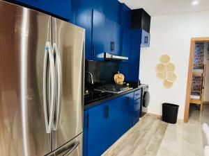 a kitchen with blue cabinets and a stainless steel refrigerator at The Beauty and The Beach in Nagua