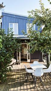a patio with a table and chairs in front of a house at Cardinalis house in Pāvilosta