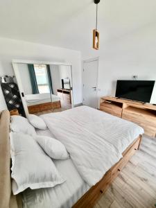 a bedroom with a large white bed with pillows at SeaTok & Stay in Costinesti