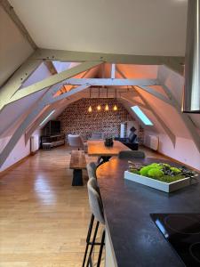 a room with an attic with a table and chairs at Côté Gîtes 9 personnes Cassel in Cassel