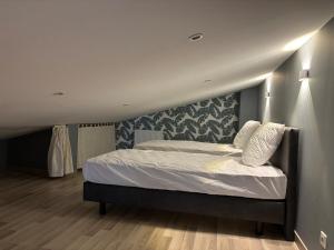 a bedroom with a large bed with white sheets and pillows at Côté Gîtes 9 personnes Cassel in Cassel