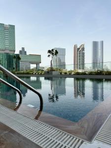 una piscina de agua con una ciudad al fondo en Comfortable 1 Bedroom with Balcony Vista 1, en Abu Dabi