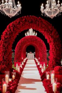 a wedding aisle with red flowers and candles at Short Times Couple Guest House in Karachi